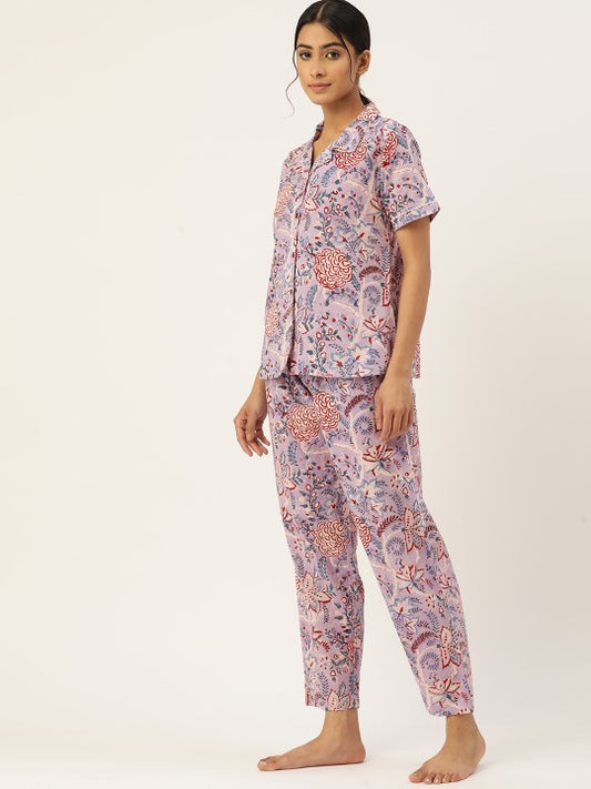Woman wearing a pink floral pajama set on a white background