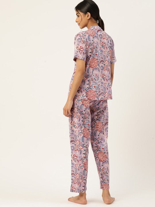 Woman wearing a floral pajama set on a white background