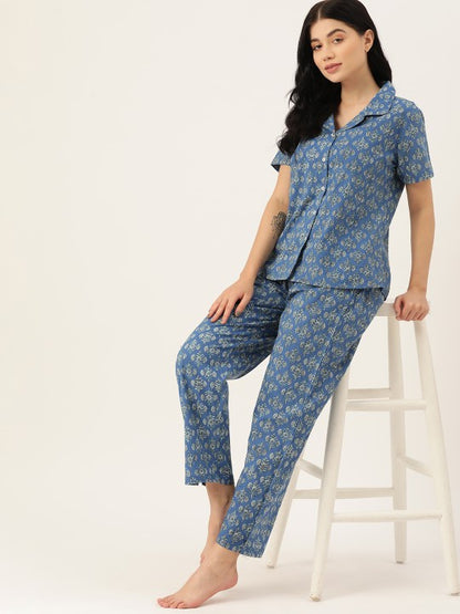 Woman wearing a blue floral pajama set on a white background