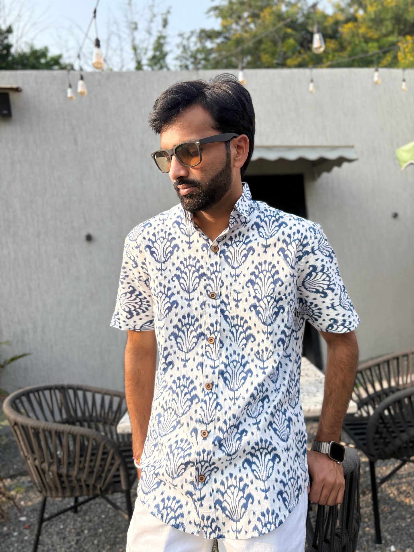 Man in patterned shirt with sunglasses near plants