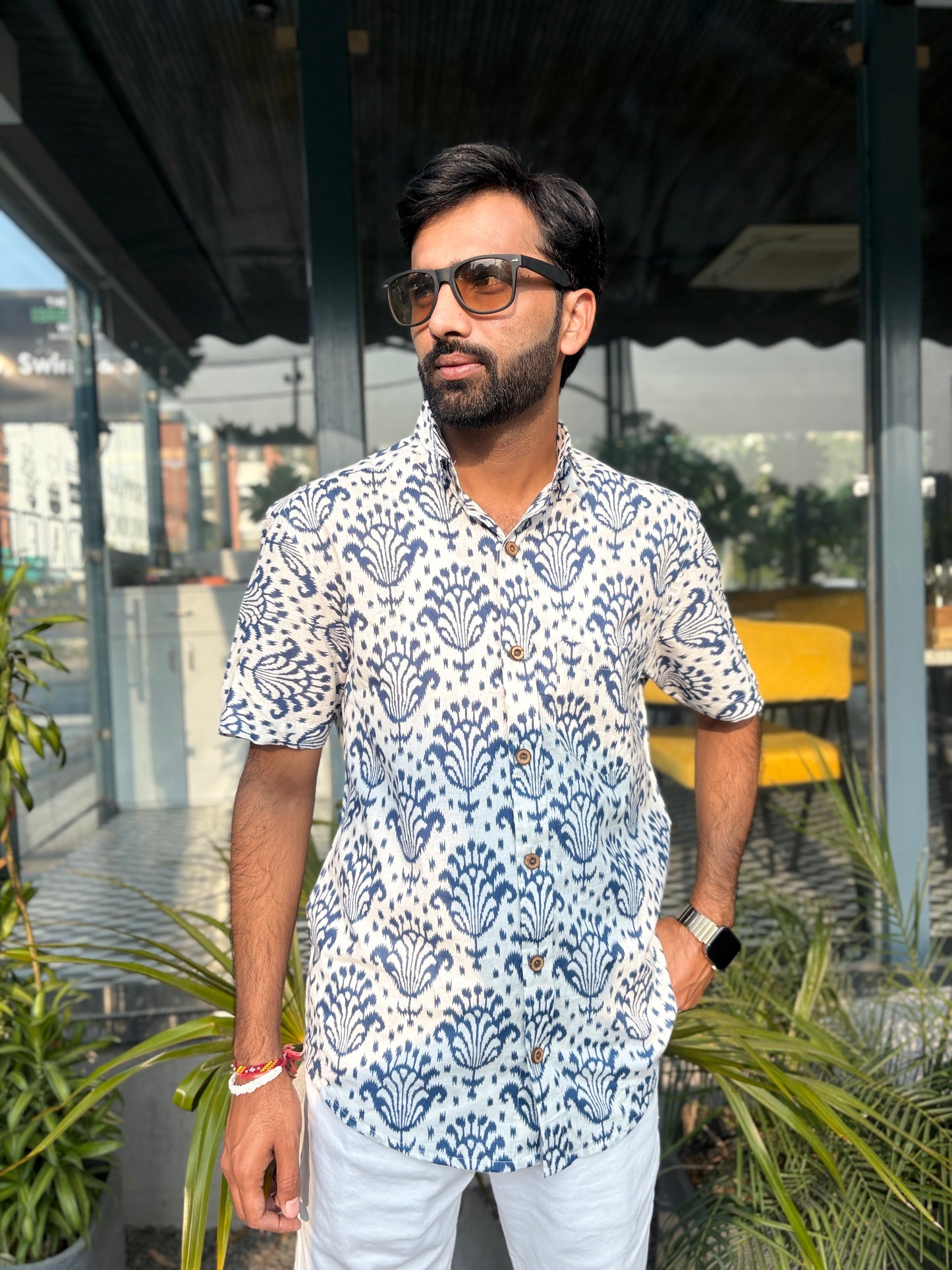 Man wearing patterned shirt and sunglasses outdoors