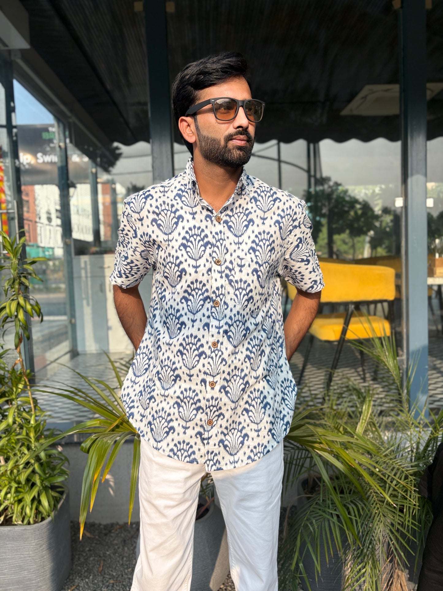 Man wearing patterned shirt and sunglasses outdoors