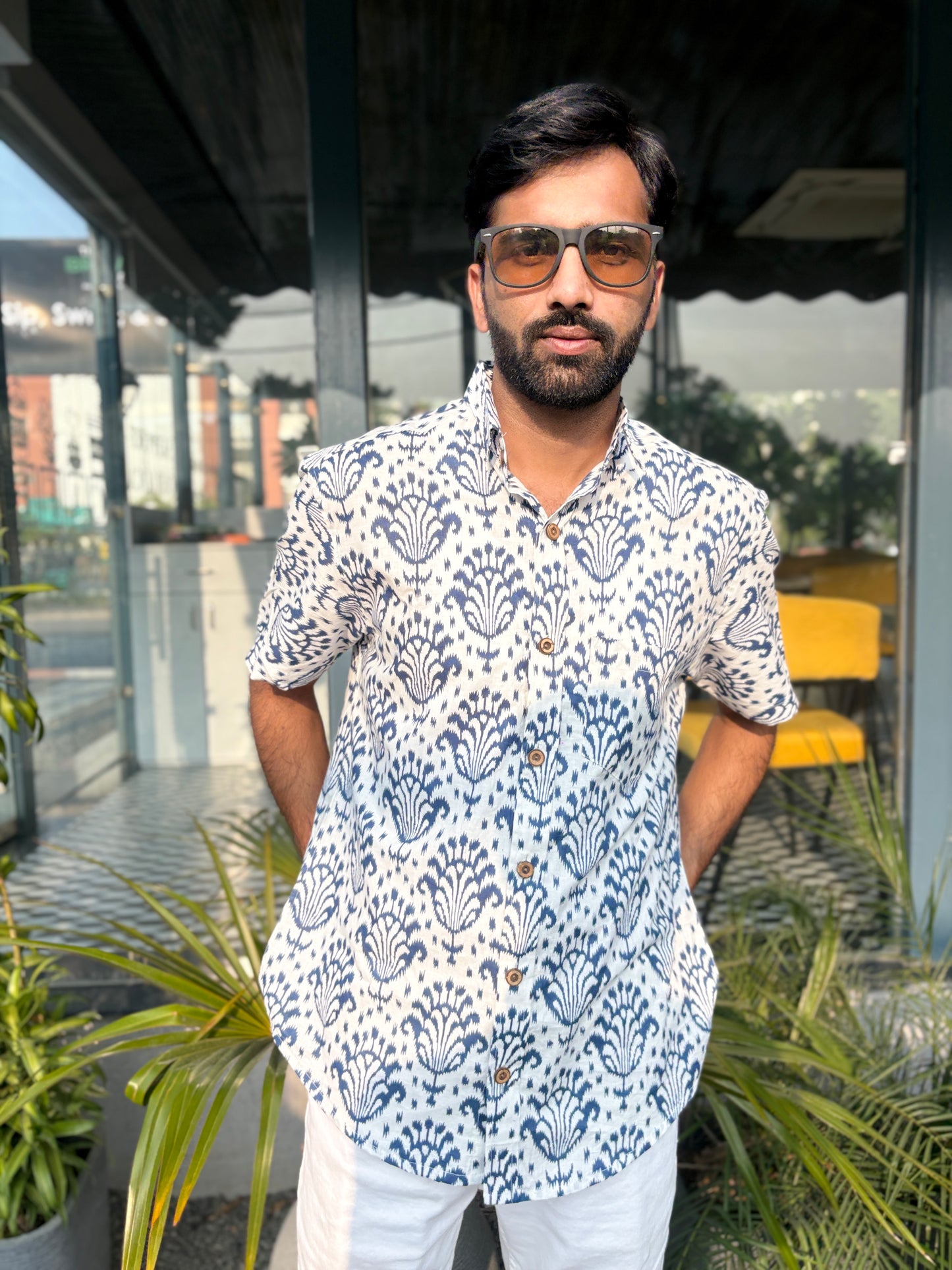 Man wearing patterned shirt with sunglasses outdoors