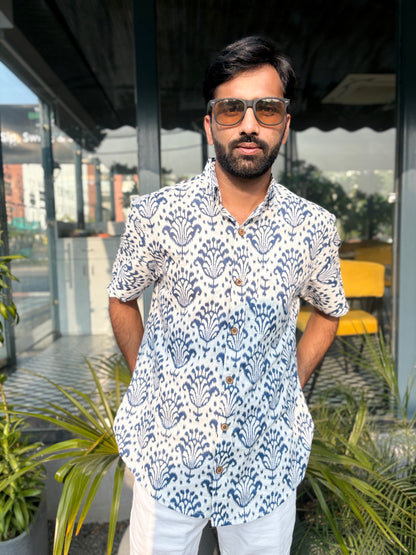 Man wearing patterned shirt with sunglasses outdoors