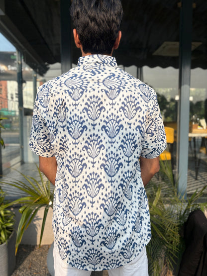 Person wearing white shirt with blue pattern outdoors