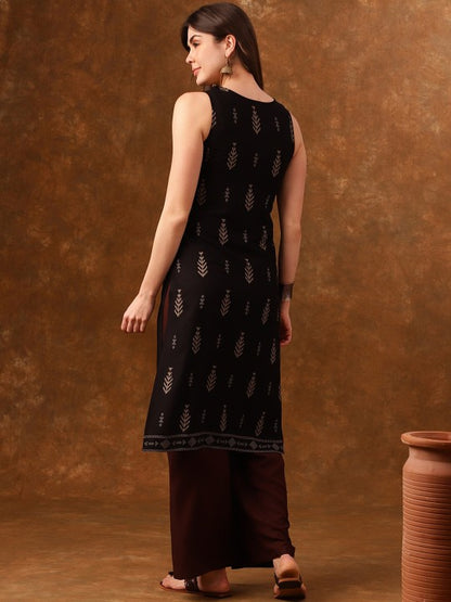 Woman wearing black sleeveless top with gold patterns