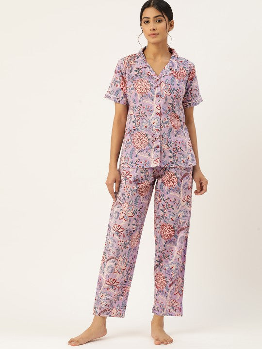 Woman wearing a pink floral pajama set on a white background