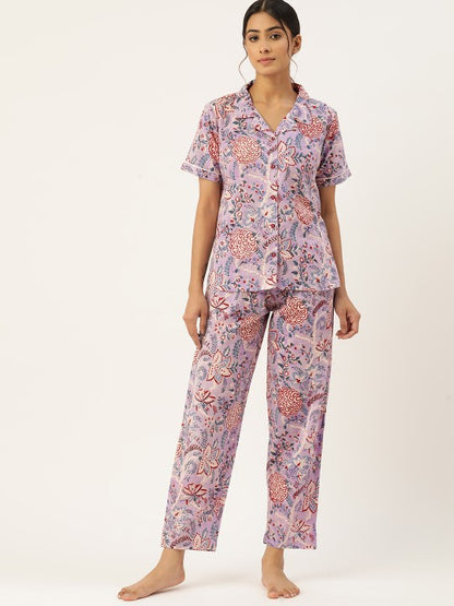 Woman wearing a pink floral pajama set on a white background