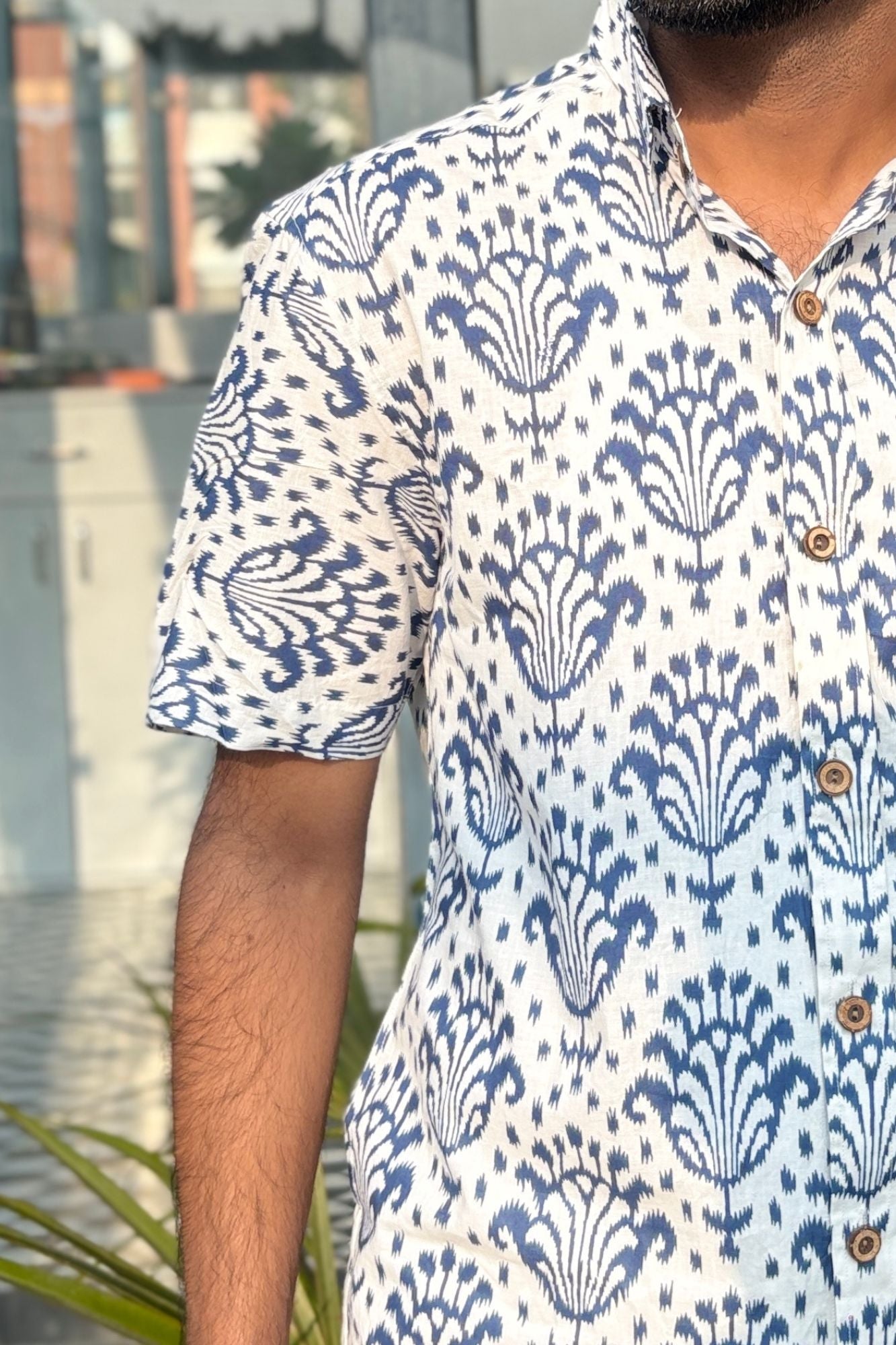 Man wearing patterned shirt against neutral background